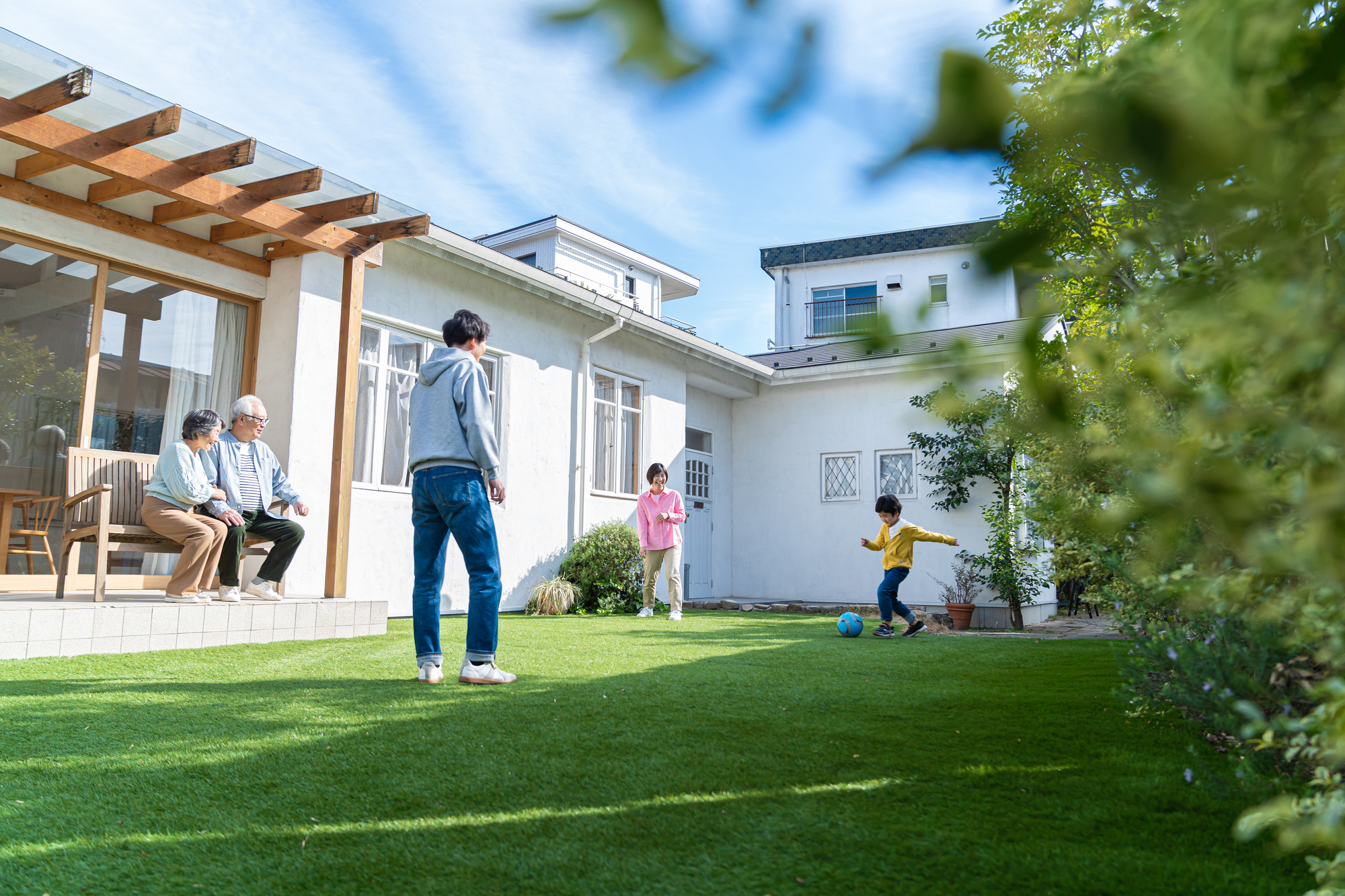 戸建て住宅の庭で過ごす家族